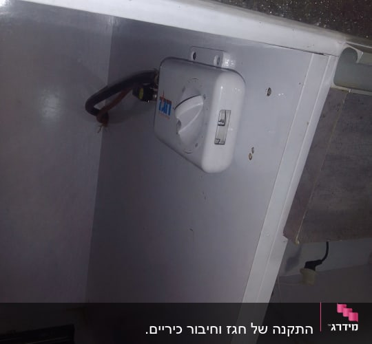 מתג חשמלי לבן עם חוגה מותקן על קיר